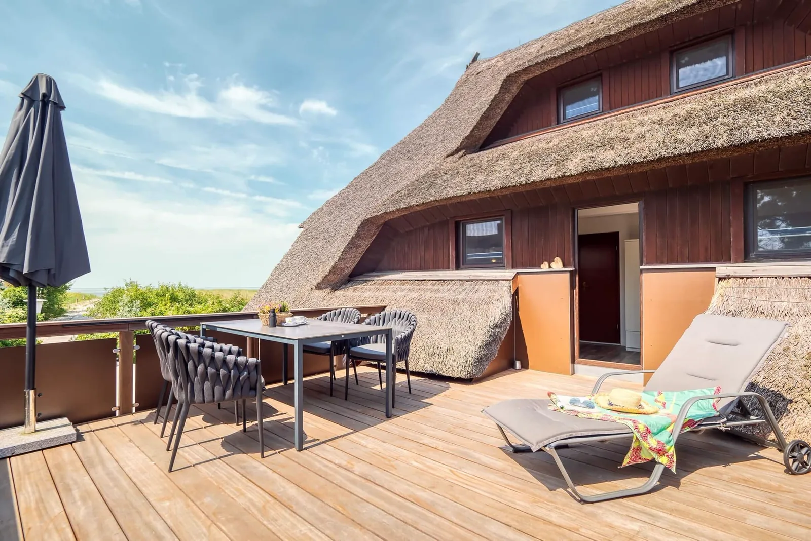 Sitzgruppe auf der Dachterrasse vor dem Reetdach von Haus Windhook