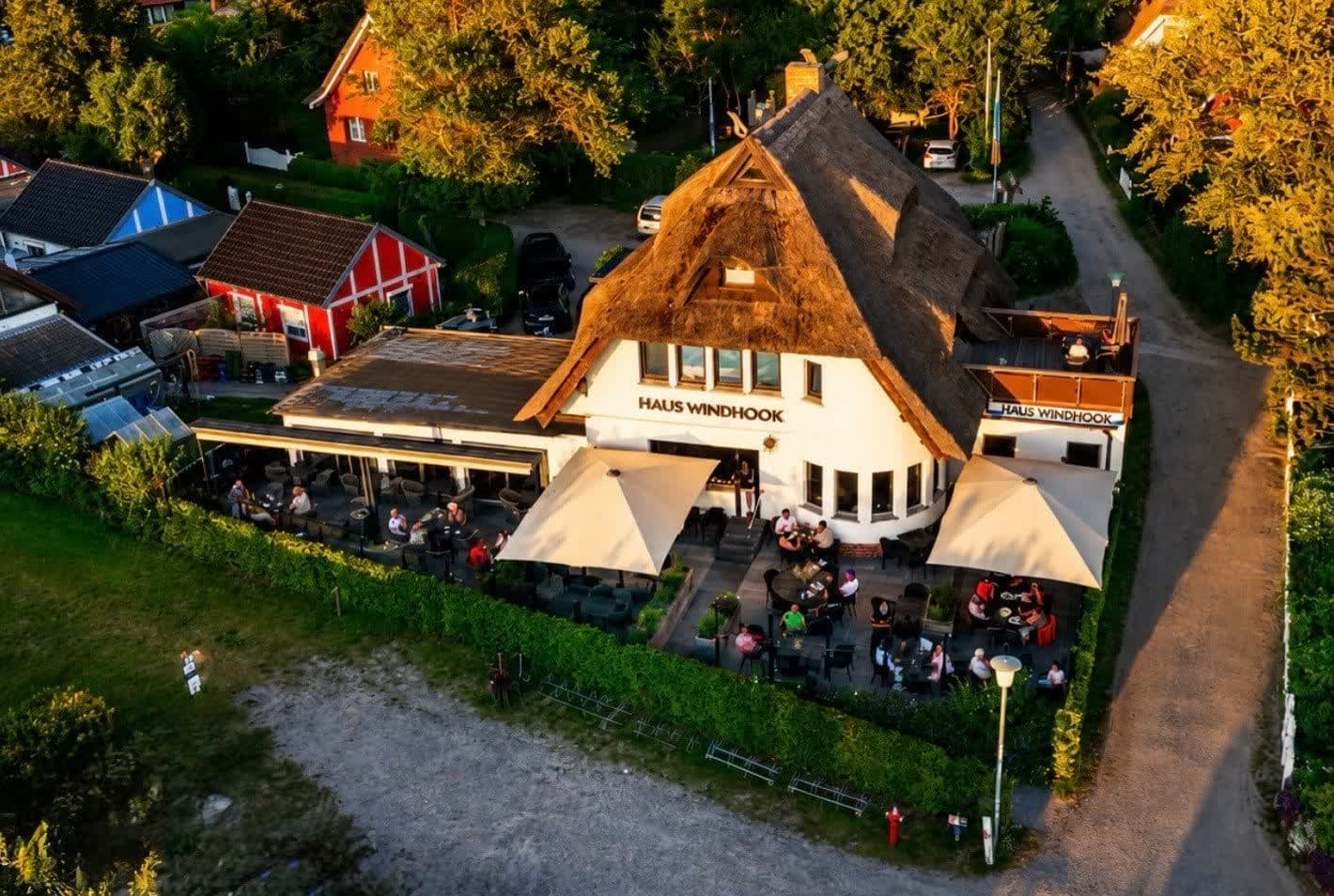 Reetgedecktes Restaurant Haus Windhook mit Terrasse im Abendlicht