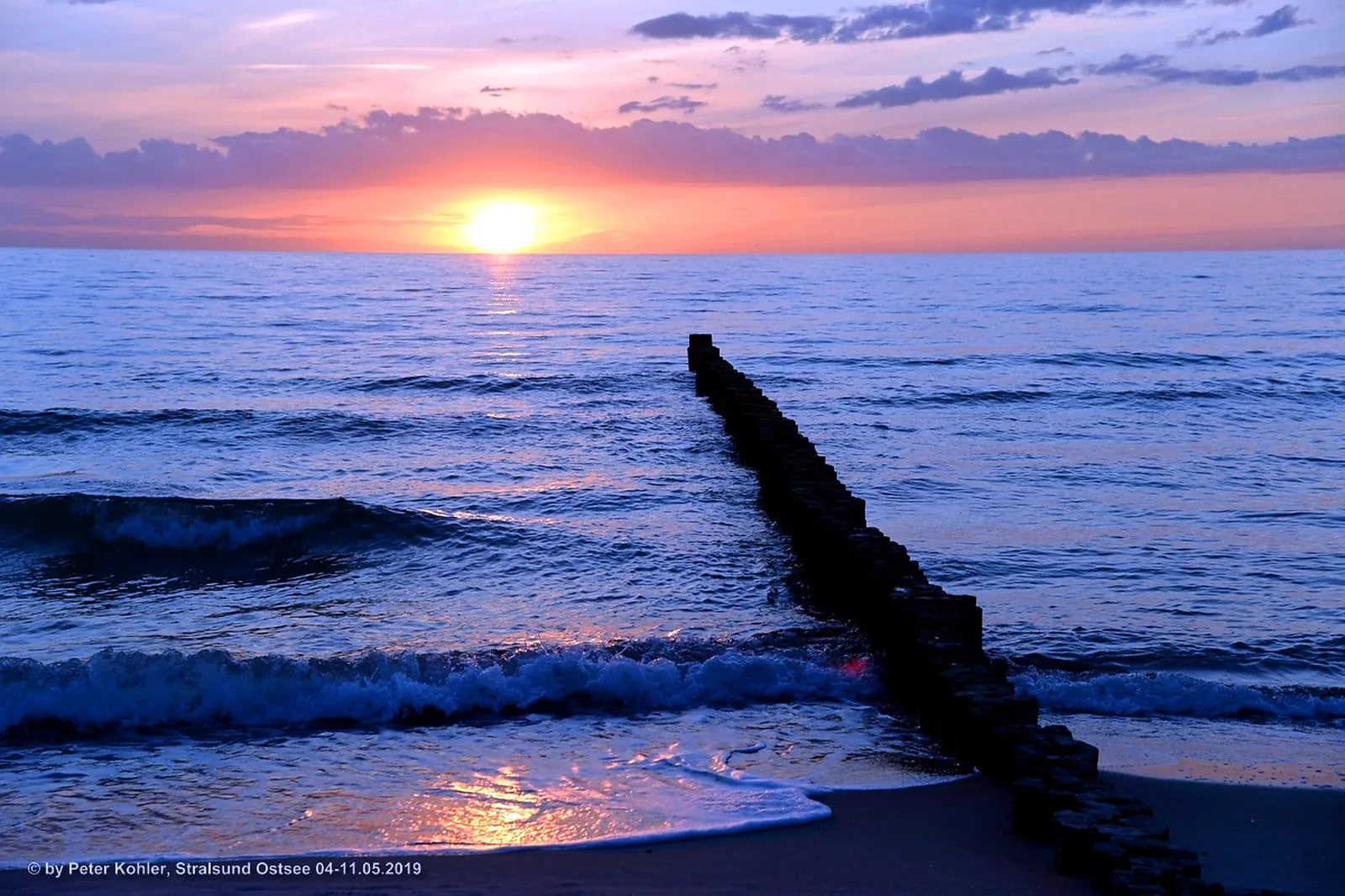 Sonnenuntergang über der Ostsee mit Buhne im Wasser